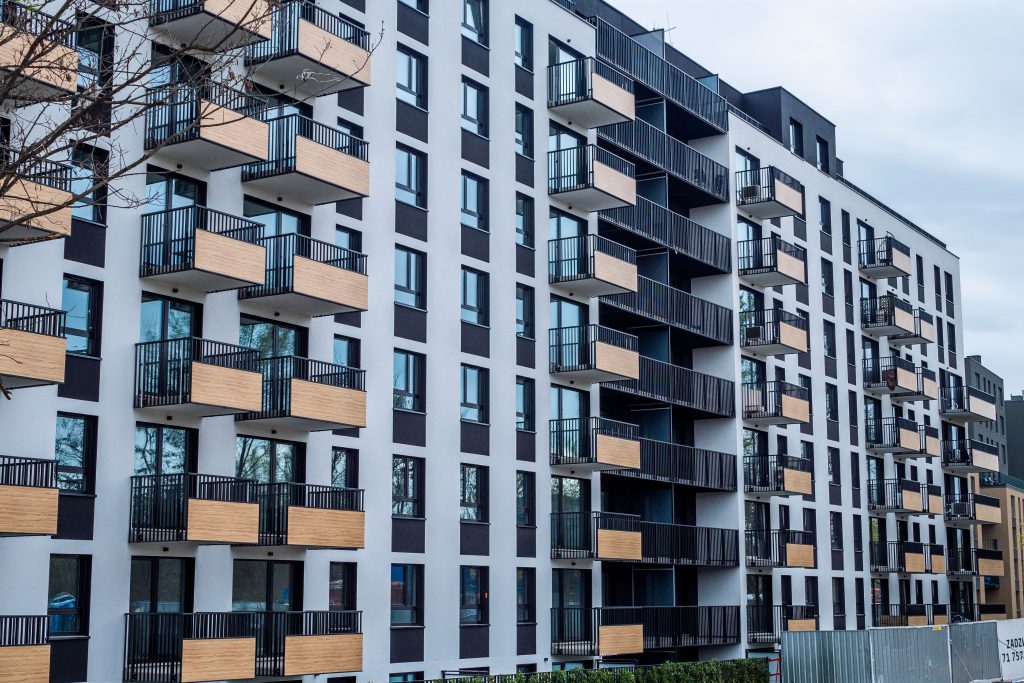Contemporary apartment building with balconies in urban setting, showcasing modern architecture.